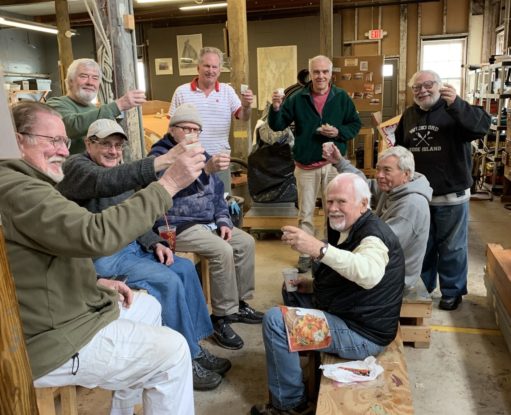 A group of smiling volunteers share a celebratory drink